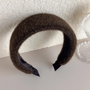Detail of plush faux fur headband in dark brown featuring a wide and thick padded texture
