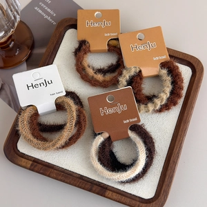 Set of four plush high-elastic hair ties in warm coffee and beige tones on a tray