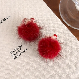 Gros plan de pompons rouges en peluche avec motifs de cœurs à carreaux sur un livre