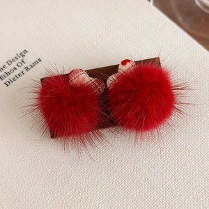 Détail de pompons en fausse fourrure rouge et tissu à carreaux en forme de cœur