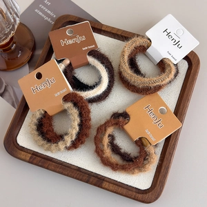 Detail of four-set thick plush hair ties in earthy tones on branded packaging cards