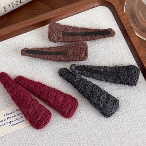 Detailed view of colorful knitted wool BB hair clips in coffee, grey, and burgundy colors