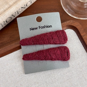 Close-up of wine red knitted triangle hair clips with crochet texture on display card