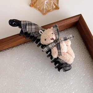 Détail d'une pince banane avec tissu à carreaux kaki et adorable ours en peluche