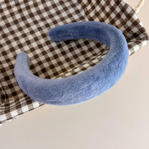 Gros plan sur un serre-tête bleu en peluche avec une texture douce en fausse fourrure