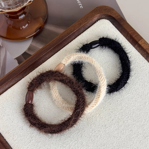 Detailed view of plush thick hair ties with glossy oval resin beads in three earthy colors