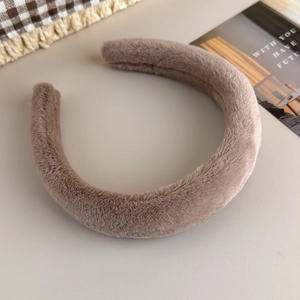 Gros plan du serre-tête épais en peluche café avec une texture douce et un rembourrage