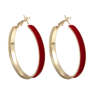 Detailed view of large gold hoop earrings with premium red velvet texture finish