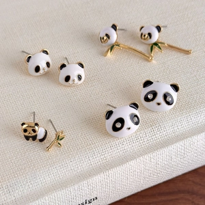 Dettaglio degli orecchini a lobo panda in smalto con base dorata e accenti in zircone