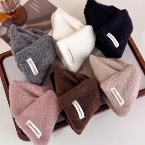 Fluffy mohair knit beanies in six colors with woven labels on a wooden tray