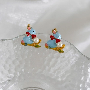 Detail of light blue enamel rabbit earrings with pearl accents and blue rhinestones