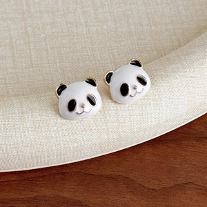 Dettaglio ravvicinato degli orecchini a lobo panda con smalto bianco nero e bordo oro