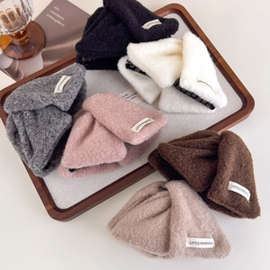 Set of six colorful plush bow shark hair clips in a wooden tray with a cozy aesthetic