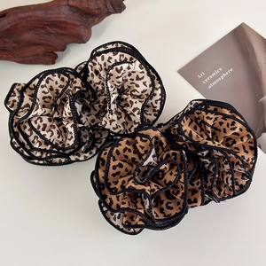 Close-up of leopard print fabric flower hair clips with ruffled edges and detailed texture