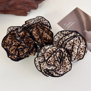 Three leopard print scrunchies in brown and beige chiffon with black stitched edges