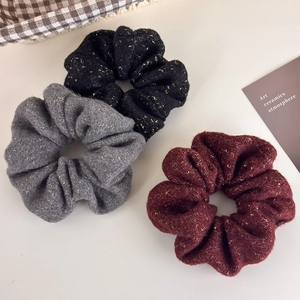 Trois chouchous en tweed texturé noir gris et bordeaux avec des fils dorés scintillants