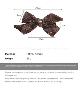 Detail of red plaid fabric bow hair clip with gold logo and measurement dimensions