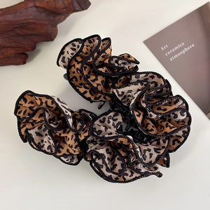 Detail of leopard print fabric banana hair clip with elegant ruffled edges and black trim