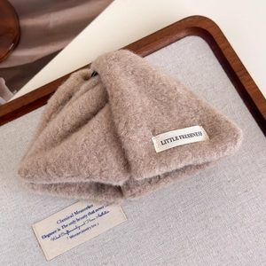 Close-up of camel plush shark hair claw clip with Little Freshness label on wooden display