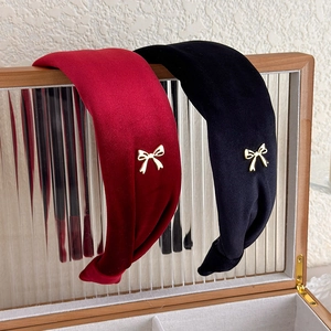 Elegant wide velvet headband set in red and black with delicate gold bow accents