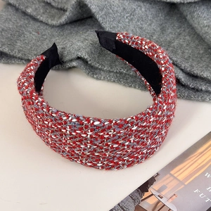 Detail van rode tweed haarsband met goudkleurige metallic draad en elegante knoop