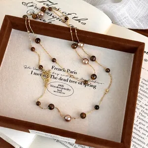 Vintage long tiger eye and pearl necklace with golden OT clasp on retro book backdrop