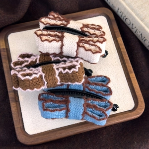 Three elegant vintage knitted bow banana hair clips set in cream, brown, and dusty blue colors