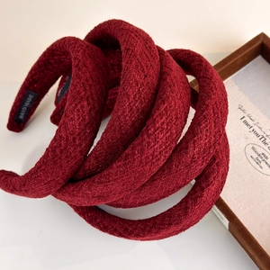 Stacked deep red wool sponge headbands with a high crown and thick fabric texture