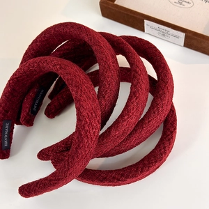 Close-up of thick burgundy tweed headbands with handmade labels and sponge padding