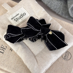 Elegant black velvet bow hair clip with white stitching and gold metal detail