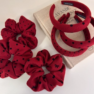 Red polka dot hair accessories set including scrunchies and headband on a book