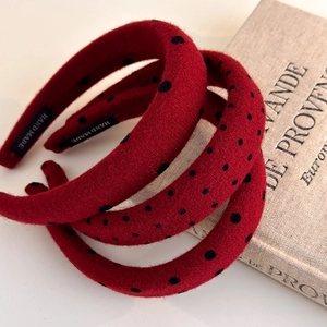 Three red polka dot padded headbands with handmade labels on a vintage book