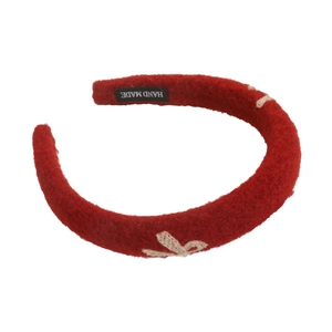 Detailed macro view of the handmade red felt headband with white bow embroidery
