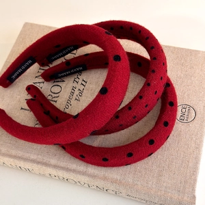 Detail view of red polka dot headband set with handmade label on vintage book background