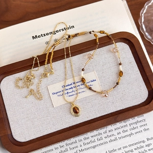 Gros plan sur le collier avec pendentif œil de tigre et l'ensemble de bracelets perlés