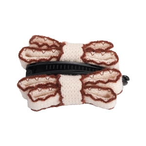 Knitted bow-shaped banana hair clip in white and brown with a retro weave pattern