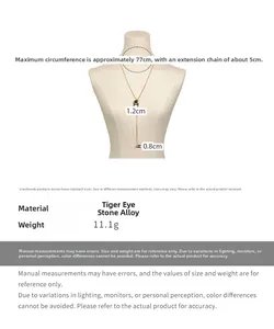 Detail view of long Y-shaped necklace with tiger eye stone and H-letter metal buckle