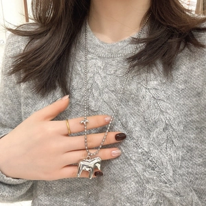 Detail view of silver bead chain necklace with dual horse pendants on grey knit sweater