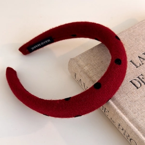 Close-up of red polka dot headband featuring a textured fabric and a handmade label