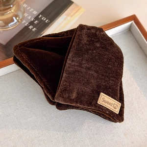 Close-up of brown velvet fabric texture with a sweet bear label on a cozy scarf