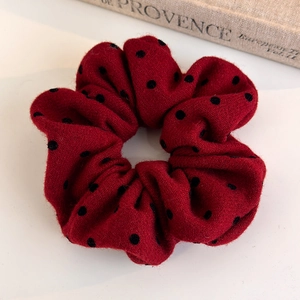 Close-up of retro red polka dot scrunchie in thick wool fabric on a vintage book