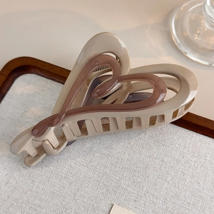 Detail of large double heart hair claw clip in coffee gradient resin on linen tray