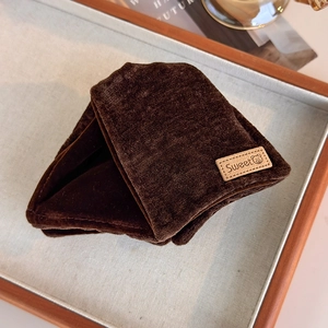 Detail view of coffee brown velvet hair claw featuring a leather Sweet label with bear