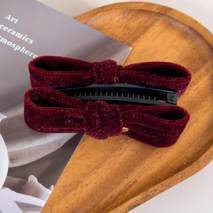 Detail of burgundy velvet banana hair clip with fine glitter and multi-tooth design