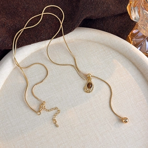 Detailed macro shot of vintage tiger eye stone pendant on golden snake chain necklace