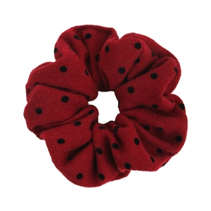 Detail of red scrunchie with black polka dots showing soft knit fabric texture