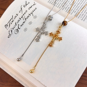 Detail of vintage gothic cross necklaces with tiger eye stones on old book pages