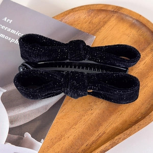 Detailed close-up of a vintage black velvet banana hair clip with shimmering glitter finish