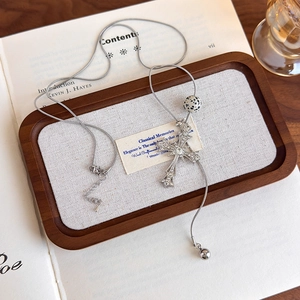 Detailed shot of tiger eye stone cross pendant on a silver snake chain over vintage books