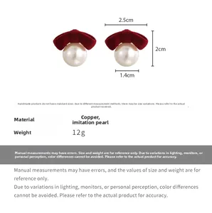 Detailed view of red flocked bow earrings with large imitation pearl and copper base